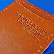 『STEINS;GATE』の完全受注生産アイテムが登場、牛革製の名刺ケースやラボメン・ピンバッジ半立体ペンダントなど