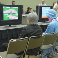 SFCのマリオカートをプレイするコスプレイヤー