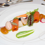 海の幸マリネと蟹のレムラード琥珀色のコンソメジュレ野菜ピューレと緑葉のコンポジション